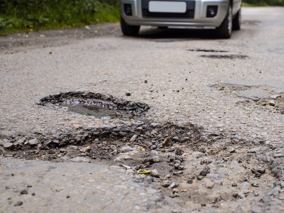 Road in terrible condition with many dangerous potholes