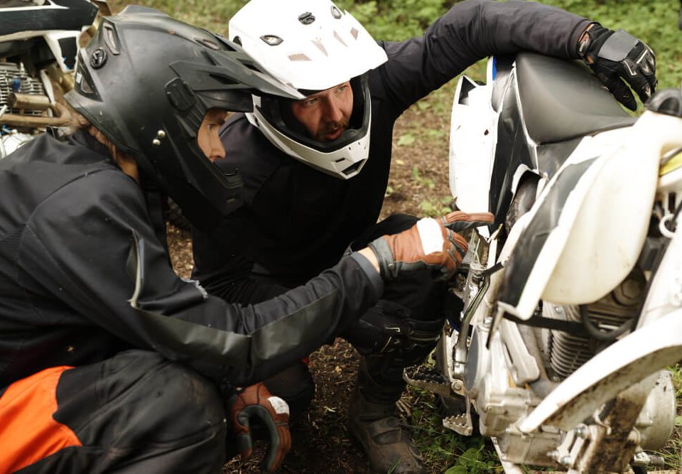 two men checking a motorcycle